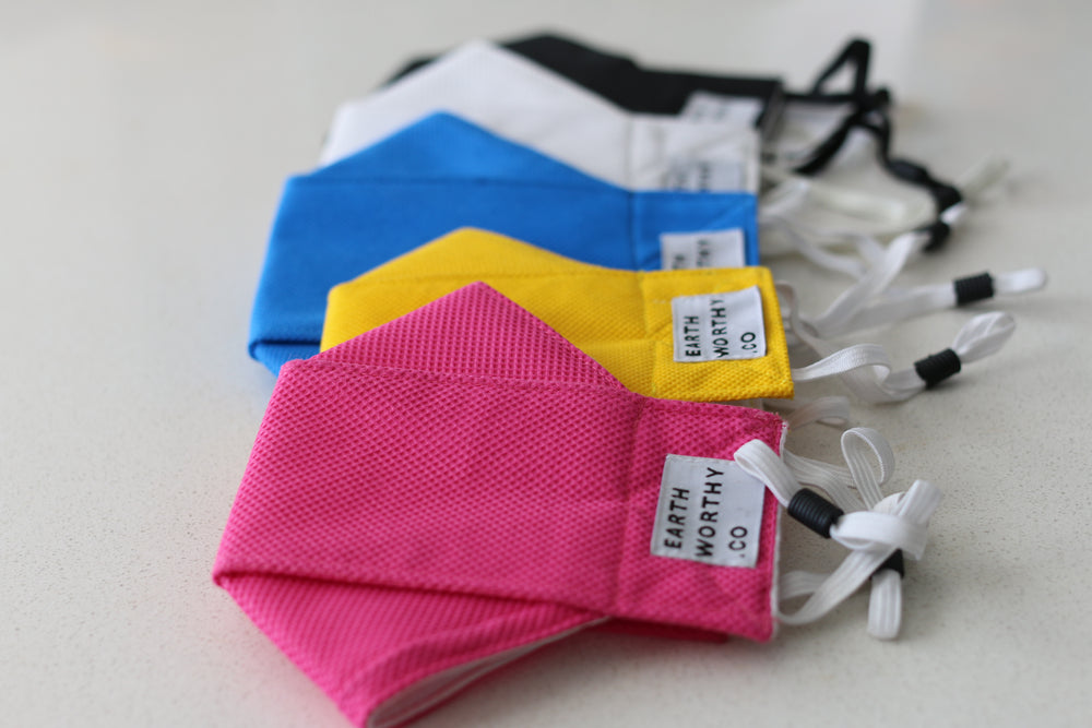 reusable face masks in pink, yellow, blue, white and black. These reusable face masks have a cotton patch that can be custom branded. The face masks are available in small for a child and medium and large for youth and adults.