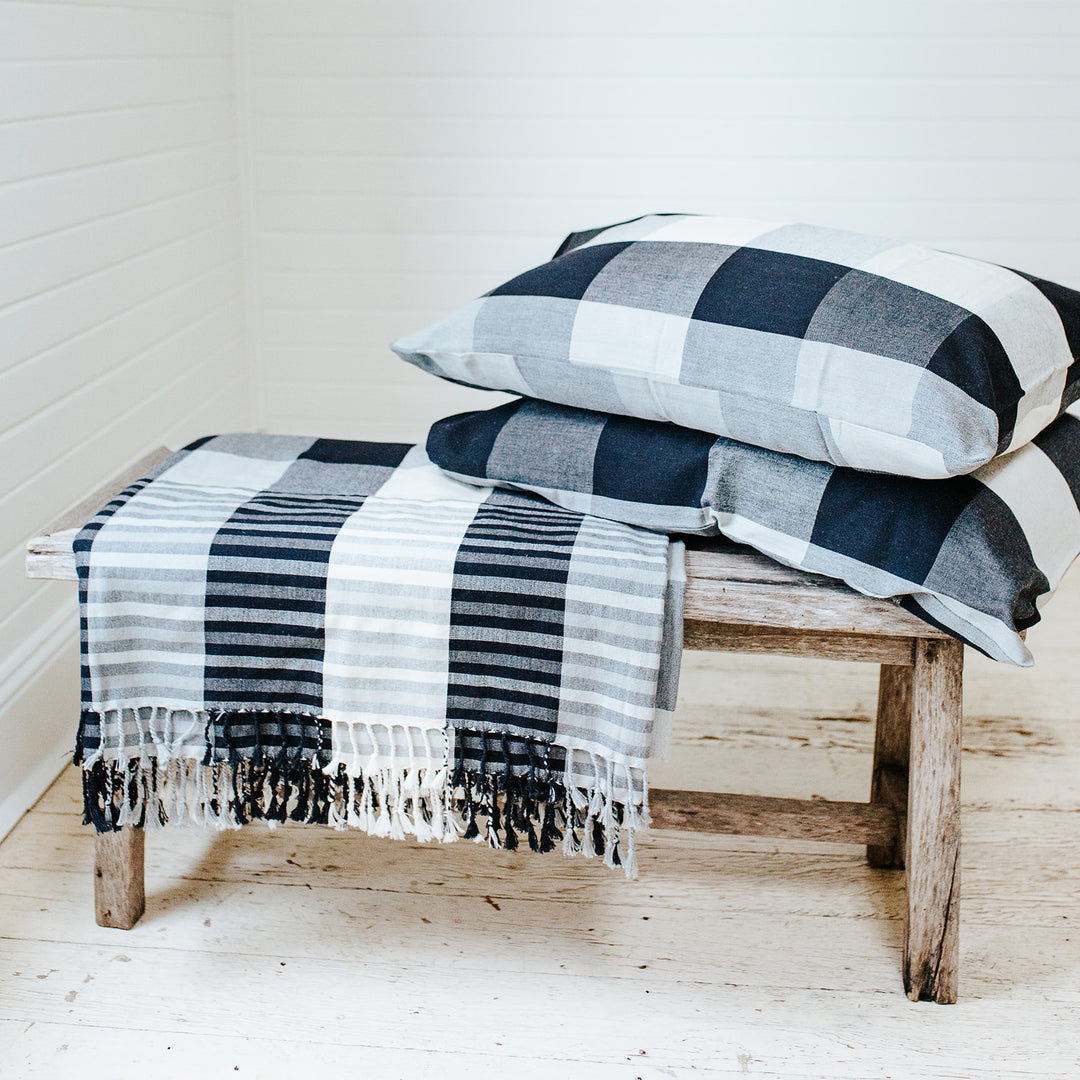 Monochrome check blanket and pillow case set displayed on bench. King size blanket with tassels. 100% cotton handloom